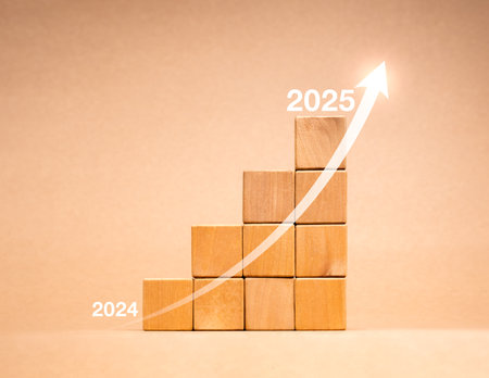 Happy new year 2025 business growing, financial investment and trends concept. Arrow rising from 2024 to 2025 on wooden cube blocks growth graph steps isolated on eco brown background, minimal style.の写真素材