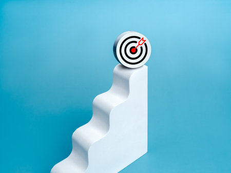 3d target icon on top of white modern geometric bar graph chart steps, isolated on blue background, minimal style. Business growth, profit financial, investment, marketing goals and trends concepts.の写真素材