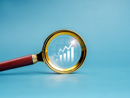 Business trends searching, online marketing, money stock analysis, investment research concept. Growth graph, rise arrow on analytic chart icon in magnifying glass lens isolated on blue background.の写真素材