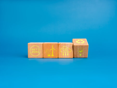 Net Zero icon and green renewable energy symbol on wooden cube blocks isolated on blue background,...