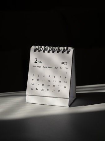 A minimalist February 2025 desk calendar for planning and reminder standing on white table, dark...