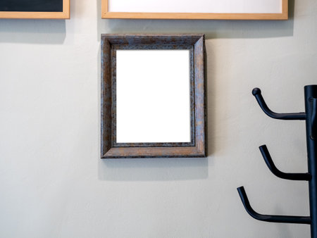 Mockup white blank space in vertical wooden square picture frame in private room at home. Empty single vintage brown rectangular simple photo frame hanging on white wall background.の写真素材