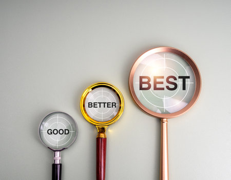 Good, better and best, Business growth and success, mission and target goal develop concept. text "Good, better and best" on gun target icons in magnifying glass lens, isolated on grey background.の写真素材