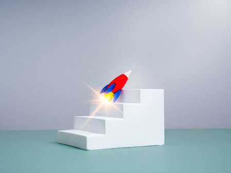 Business startup, leadership, digital marketing, financial investment, innovation technology, goal and success concept. Rocket toy flying up on white staircase as growth graph steps, white background.の写真素材