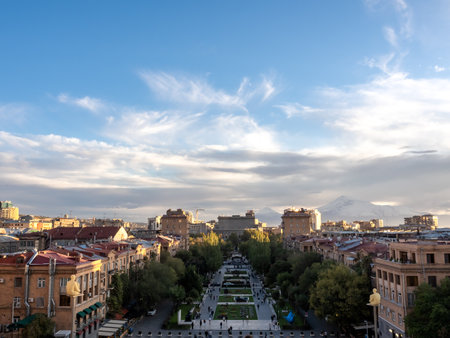 Scene of Yerevan cityscape with street buildings and trees, sunlight on sunset on blue sky background, high view from Yerevan cascade, a modern architecture building complex at Yerevan, Armenia.の写真素材