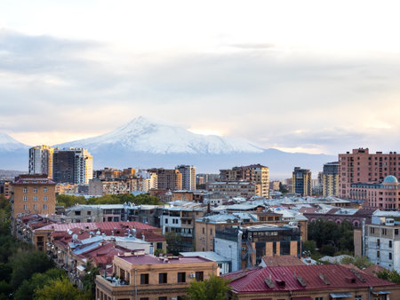 Scene of Yerevan cityscape with buildings and trees, with Mount Ararat on sky and clouds background, high view from Yerevan cascade, a modern architecture building complex at Yerevan, Armenia.の写真素材