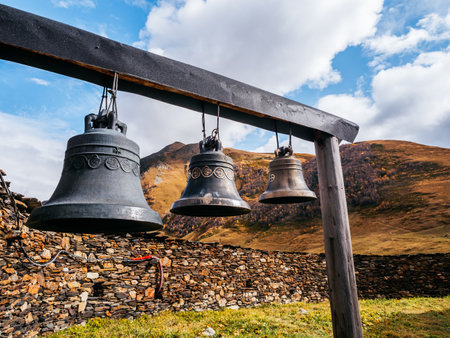 Three iron bells hang outside the Lamaria church on autumn mountains and landscape background, near the Ushguli, UNESCO heritage village, tourist attraction in the Svaneti region, Georgia.の写真素材