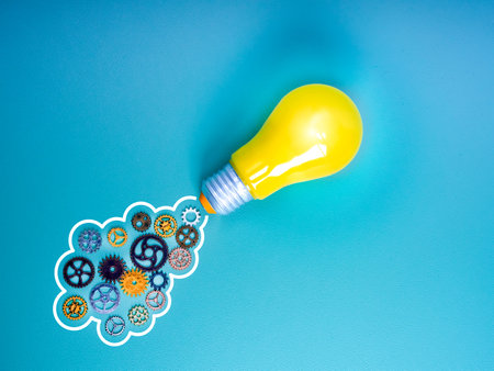 Business startup, creative idea, inspiration, education knowledge and learning, innovation concept. Yellow lightbulb as a rocket, launch with many cogwheels and gears as jet smoke on blue background.の写真素材
