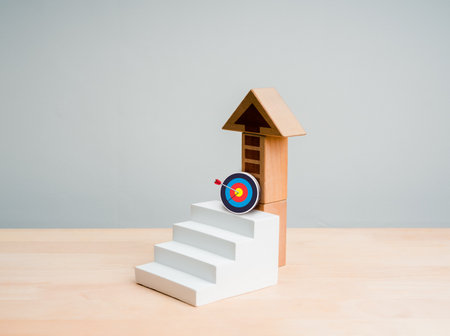 3d goal target icon on white geometric staircase as growth graph steps with wooden arrow up, isolated on grey background. Business growth and success, next step levels, self development concept.の写真素材