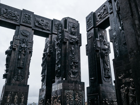 Chronicles of Georgia, monument history, design detail on black sculpture pillars, famous tourist attraction, located on Keeni hill near the Tbilisi sea, Georgia, with white fog sky after rain day.の写真素材