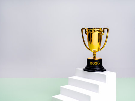 2026 happy new year, business growth, goal and success, leadership concepts. 2026 calendar numbers on gold trophy on white staircase as graph chart steps on green table, white background with space.の写真素材