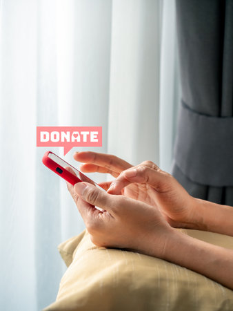 Donate icon in pink bubble speech appear on smart mobile phone in woman's hands, using cellphone...