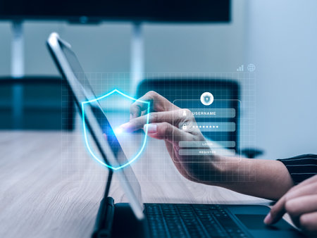 Cyber security and data protection technology concept. Shield icon showing while business person hand touching to sign in on website with internet connection on tablet computer, workplace background.の写真素材