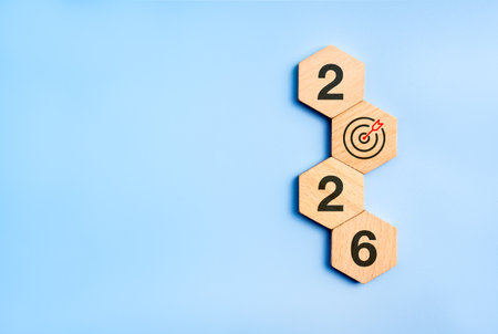 Happy new year 2026, modern minimal banner. Business goal plan, building success concept. 2026 year numbers with target icon on eco wooden hexagon blocks isolated on blue background with copy space.の写真素材
