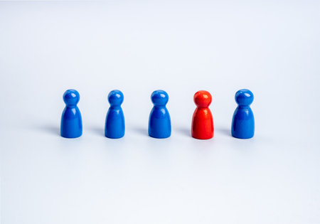 Stand out from the crowd, leadership, unique, influencer, talent people, difference concept. The red one standing different in the group of blue wooden figures, people symbols, on white background.の写真素材