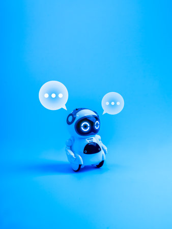 Conversational AI, AI agent, chatbot assistant tools, artificial intelligence communication, and customer service bots technology. Cute robot with glowing eyes and speech bubbles on blue background.の写真素材