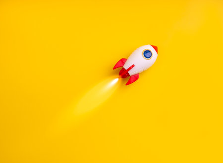 Creative rocket toy flying on vibrant yellow background represents startup concept, new project launch, technology idea, innovation strategy, fast growth, and business success in a dynamic market.の写真素材