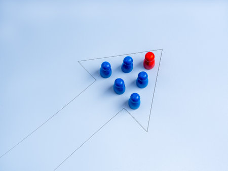 Leadership concept with red figure leading blue team in arrow formation on light background, representing business growth, vision, teamwork, strategic planning, leadership skills, success direction.の写真素材