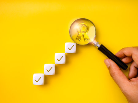 Step-by-step checklist blocks with magnifying glass focused on gold award icon represent personal development, quality standards, performance improvement, evaluation process, and success achievement.の写真素材