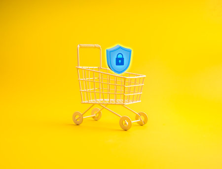Shopping cart with 3d padlock shield icon on yellow background represents e-commerce security, online shopping protection, data privacy, cybersecurity, payment safety, and secure transactions.の写真素材