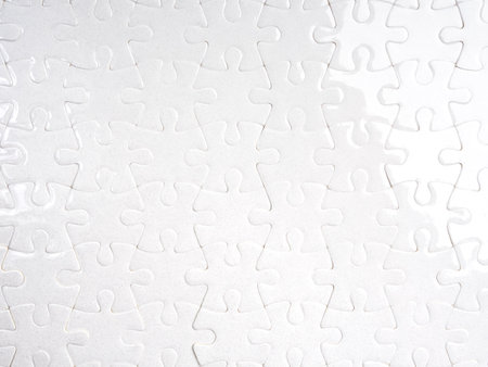 White jigsaw puzzle fully assembled with clean minimal look, representing completion, teamwork, integration, problem-solving, unity, and system connection on plain light background with soft texture.の写真素材