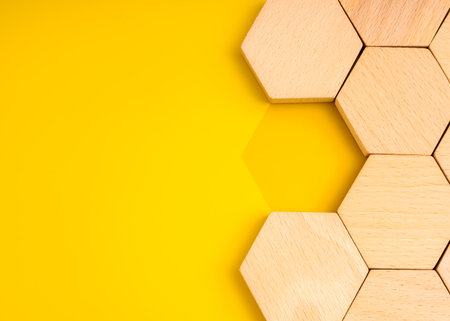 Hexagon wooden blocks with one missing piece on yellow background, symbolizing missing part, recruitment, hiring, team building, and business solution concept. Perfect for HR and strategy content.の写真素材