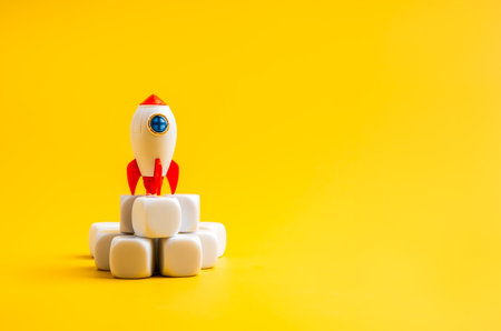 Toy rocket on white pile cube blocks with yellow background representing creative startup launch, and business growth concept. Perfect for innovation, entrepreneurship, and success-driven content.の写真素材