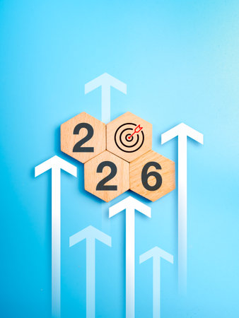 Wooden hexagon blocks showing 2026 and target icon with upward arrows on blue background,...