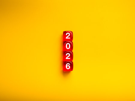 Red dice stacked to form number 2026 on yellow background. Creative concept for new year, fresh start, planning, opportunity, and future vision. Ideal for business goals, and celebration themes.の写真素材