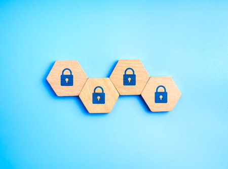 Lock icons on hexagon wooden blocks on blue background symbolizing cybersecurity, data protection, password safety, encryption, privacy, secure network, online security and digital information safety.の写真素材