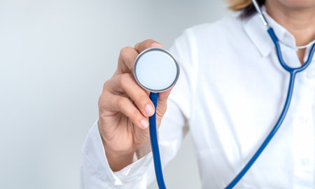 Doctor holding stethoscope for health checkup and medical examination on white background. Healthcare professional service, preventive care, diagnosis, and wellness support in hospital or clinic.の写真素材