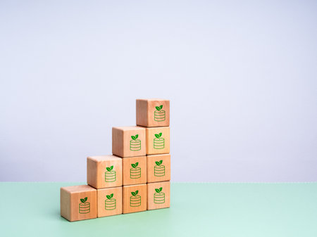 Green finance and sustainable business growth concept with wooden blocks stacked in stair shape,...