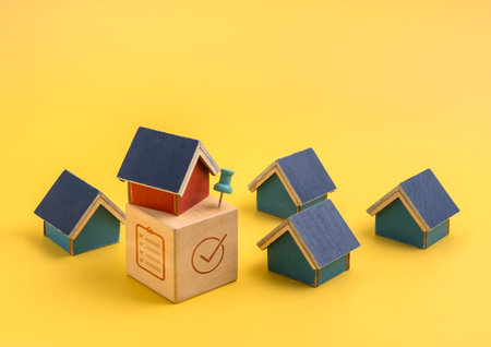 Minimal concept of property value and house selection with one highlighted house above checklist cube. Represents real estate decision-making, buying home, appraisal, and investment strategy.の写真素材