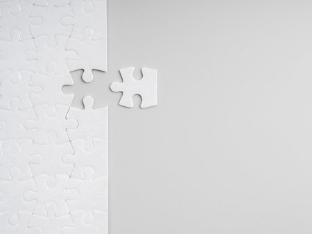 Minimal white puzzle with missing piece on grey background with copy space. Concept of solution, strategy, problem solving, business planning, completion, finding the right fit, and filling the gap.の写真素材