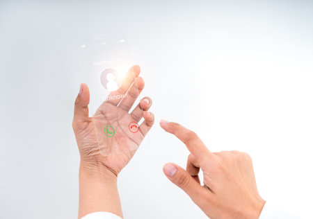Futuristic transparent glass phone with incoming call display in human hand. Innovative concept for future technology, AR interface, digital communication, and advanced mobile user interaction design.の写真素材