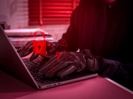 Cybersecurity threat concept showing hacker or scammer using laptop with glowing red unlocked...