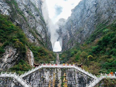 Stunning view of Heavenâs Gate cave at Tianmen Mountain, China, with steep stairs, misty cliffs, sacred atmosphere, for adventure and cultural tourism, Zhangjiajie, Hunan, China.のeditorial素材