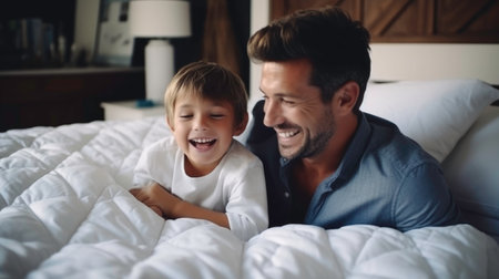 Caucasian fathers using digital tablet on bed with sonの素材