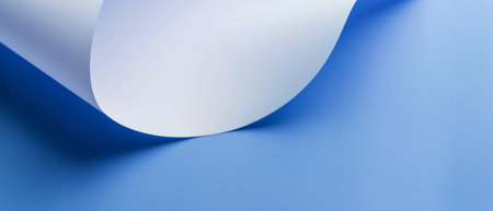 A roll of white paper is placed on a smooth blue surface. The roll is cylindrical in shape and contrasts sharply with the vibrant blue background. The paper appears clean and unmarked, ready for use.の素材