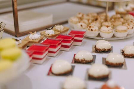 Beautifully decorated catering banquet table with burgers, profiteroles, salads and cold snacks. Variety of tasty delicious snacks on the tableの写真素材