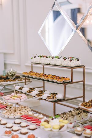 Beautifully decorated catering banquet table with burgers, profiteroles, salads and cold snacks....
