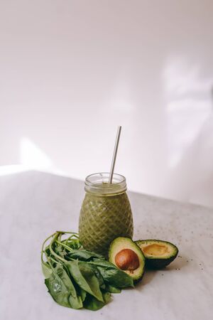 Organic and healthy green smoothie with banana, spinach, avocado, citrus fruits and chia seeds in a glass bottles on a rustic background withcopy spaceの写真素材
