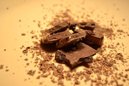 Pieces of chocolate on a background of fine chips. Top viewの写真素材