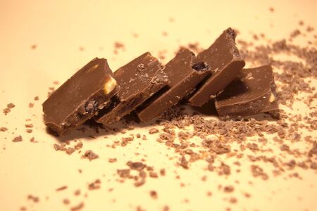 Pieces of chocolate on a background of fine chips. Top viewの写真素材