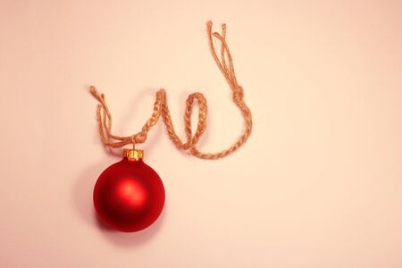 Christmas red matte ball hanging on a waxed thread on a light plain background. Copy spaceの写真素材