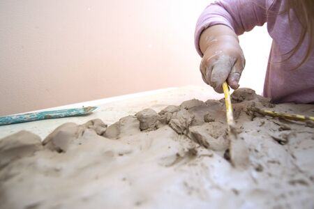 little girl works with clay at the table. Time for childrens creativity. Clay petal with a baby. Previously, the development of the child. A Conscious Childhoodの写真素材