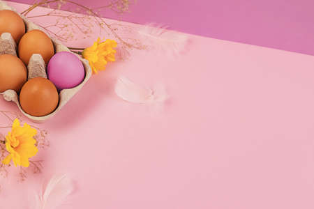 Easter eggs and spring flowers on a colorful background. Happy Easter. Holiday concept. Copy space.
