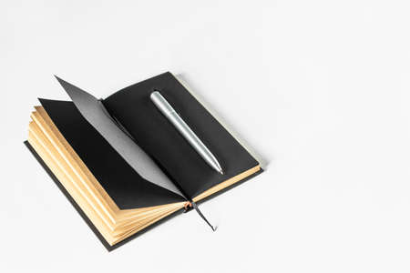 Stylish notebook for notes with pen. Opened notebook with black pages on a white background. Copy...