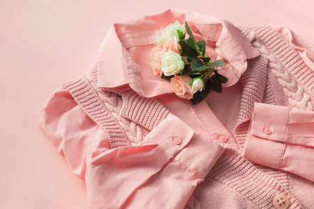 Background with fashionable clothes. Pink jersey and shirt with a bouquet of flowers. Beauty blog concept.の写真素材