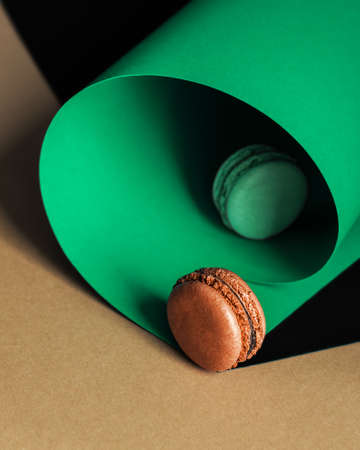 French macaroons on a multi-colored paper background with place for text. Pastry chef app with copy space. Creative conceptの写真素材